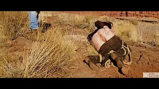 Enormous-rear-end blonde gets her butthole whipped, then gets rough anal sex in dirt and piss -- a real BDSM session outdoors in the Western USA with Rebel Rhyder